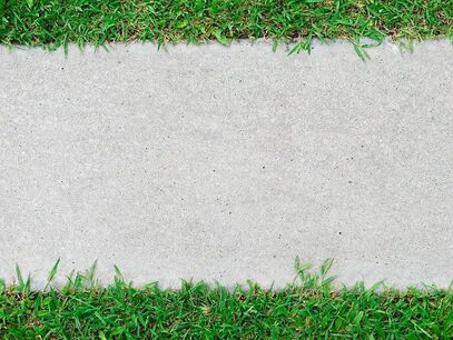 A top down view of a slab of concrete in grass that has been lifted back to proper level.