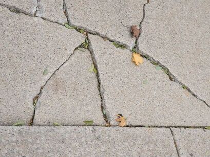 A concrete slab with several crack in need of repair.