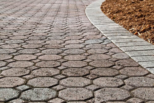 A close up view of a gray colored stamped concrete in a stone pattern and texture.